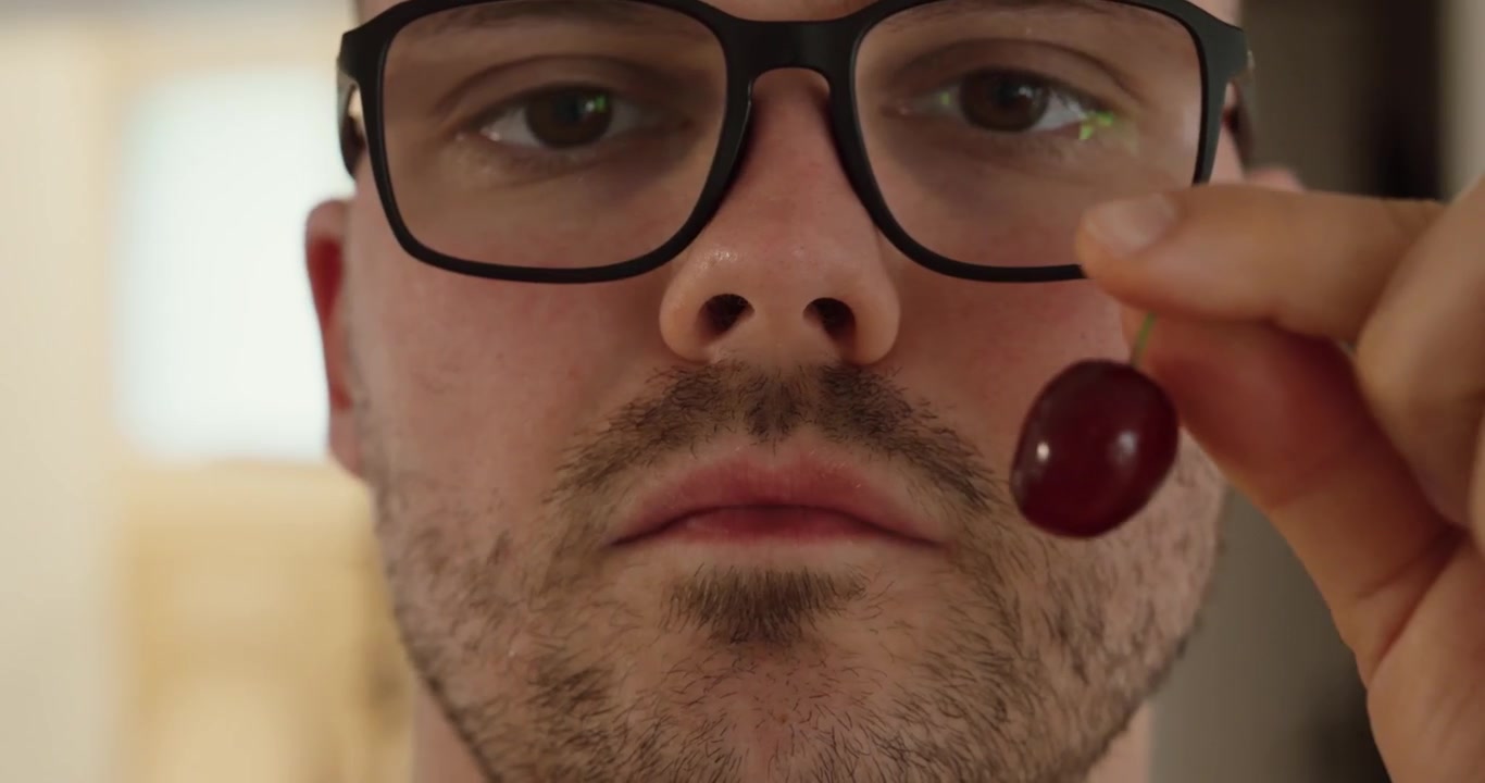 Primo piano di una persona che mangia una ciliegia fresca e rimuove il nocciolo. Concetto di alimentazione sana che presenta frutta fresca, nutrizione e cibo naturale.