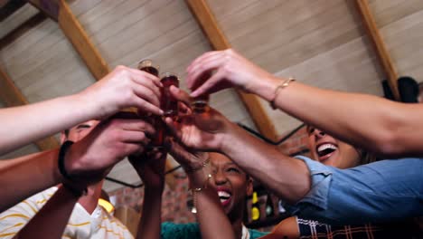 group of friends interacting while toasting a shot glasses