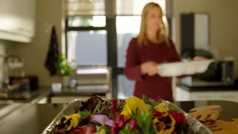 Beautiful-woman-holding-food-tray-in-kitchen-at-home-4k