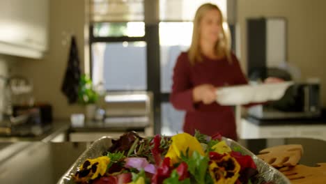 hermosa mujer sosteniendo bandeja de comida en la cocina en casa 4k