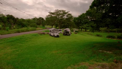 a zoom-in of camping vehicles with roof tents by the roadside