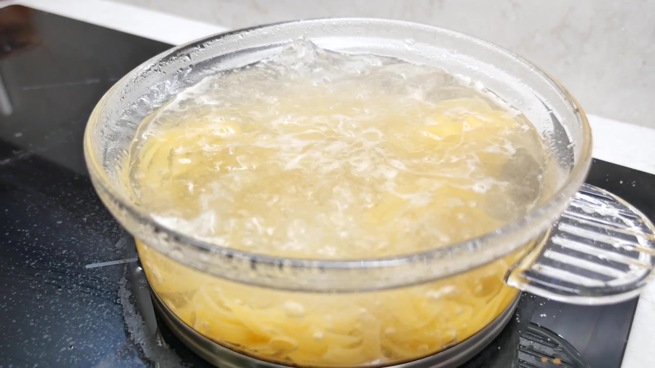 Pasta che bolle in una pentola di vetro su un fornello