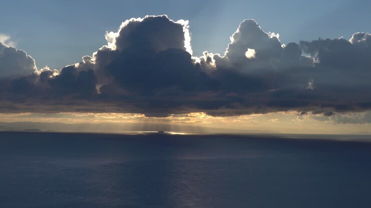 Stunning time lapse with moving cumulus clouds above ocean during sunset