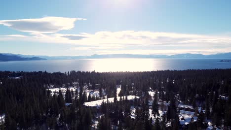 Toma-Aérea-De-Drones,-Vista-Sobre-El-Lago-Cristalino-Mientras-Desciende-En-El-Bosque-En-El-Lago-Tahoe,-Nevada-california