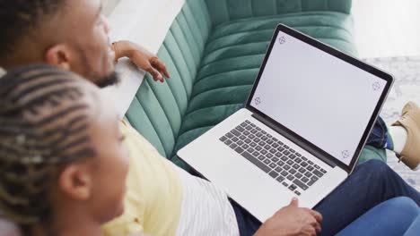 Happy-african-american-couple-talking-to-camera-during-video-call-on-laptop-with-copy-space