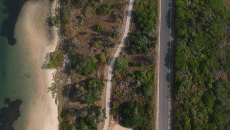 Vista-Aérea-De-Una-Carretera-Interior-Y-Un-Sendero-Que-Recorre-La-Tierra-De-Arbustos-Nativos-Australianos-Situada-Cerca-De-Un-Gran-Billabong