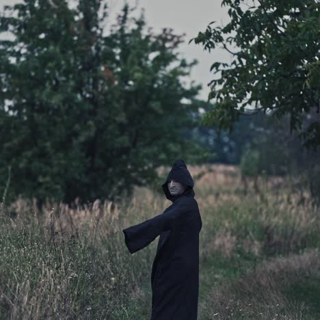mysterious hooded figure in a dark field