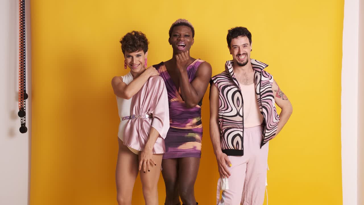 Trans men posing while smiling at the camera in a photographic studio