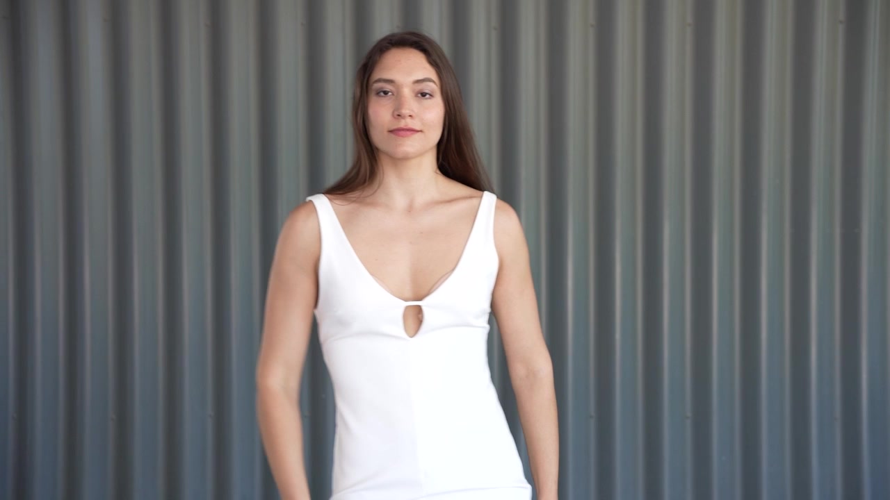 Una posa di danza aggraziata catturata in un elegante abito bianco con un tocco artistico e bellezza.