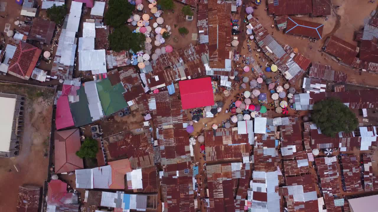 Top down aerial of a large African market in Karshi, Nigeria. Vendors sell their merchandise to people roaming through the shanty town