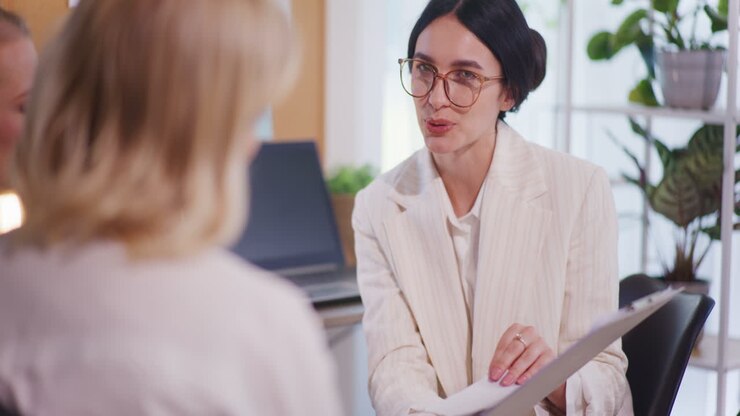 Woman Discusses Business Topics at Meeting with Female Employees