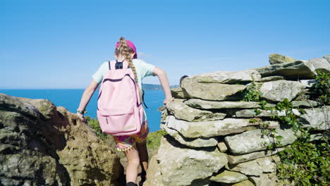 children hiking through stone walls by the coast