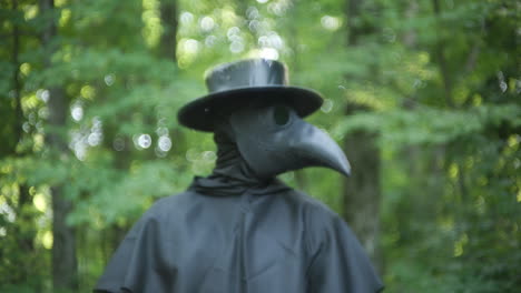 plague doctor standing in forest in slow motion