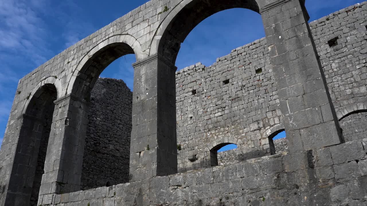 Architettura medievale di un tempio con pareti in pietra ad arco all'interno del castello di Rozafa.