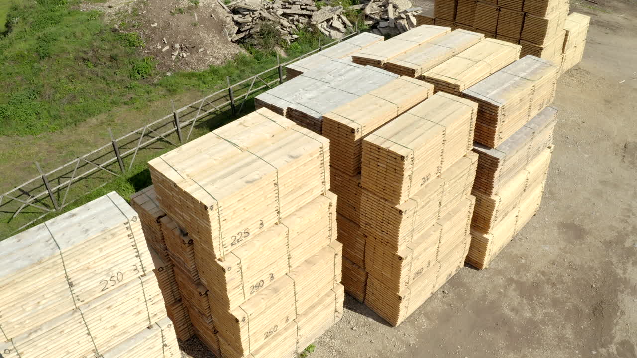 disparo de dron de material de madera apilado - vuelo hacia arriba, panorámica hacia abajo creando un arco