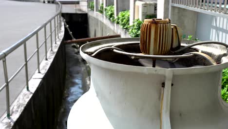 3 phase induction motor. the function is to drain or pump water. the exterior is old and rusty. the subject is on the right.