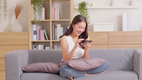 happiness entrepreneur beautiful business asian young woman wear casual use mobile phone for shopping online laughing enjoy with social media and laptop at home.small business startup.online banking