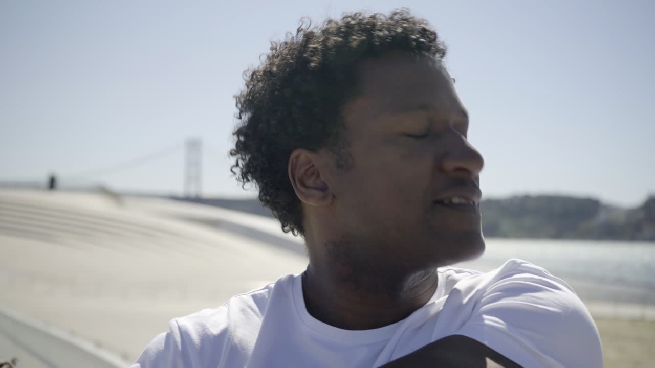 un primer plano de un hombre afroamericano sonriente entrenando al aire libre.