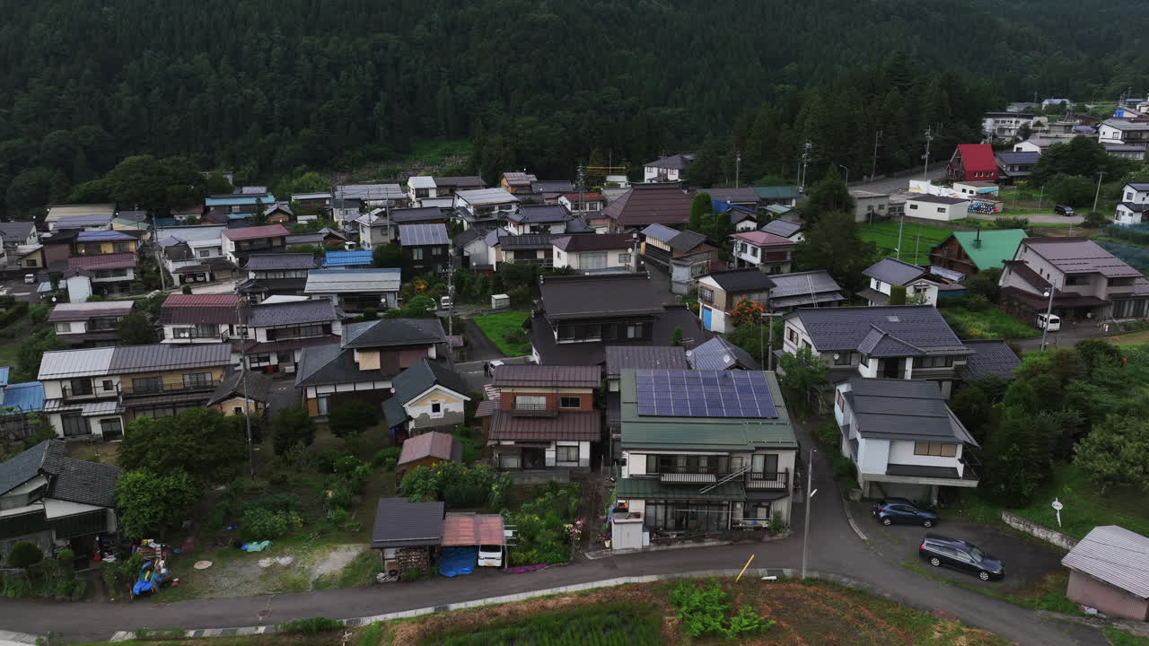 드론은 구름이 가득한 일본 교외의 고전적인 이웃 집을 내려다보는 사진을 찍었습니다.