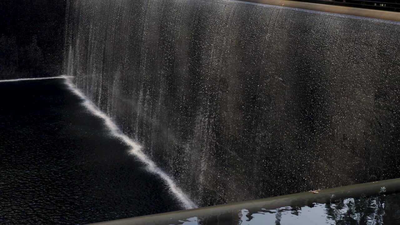 Slow motion landscape of water fountain running at National September 11 Memorial and Museum 911 World Trade Center Ground Zero New York City USA America travel tourism