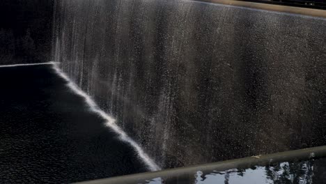 slow motion landscape of water fountain running at national september 11 memorial and museum 911 world trade center ground zero new york city usa america travel tourism