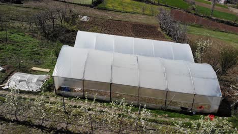 invernadero en tierras agrícolas del paisaje del pueblo en primavera