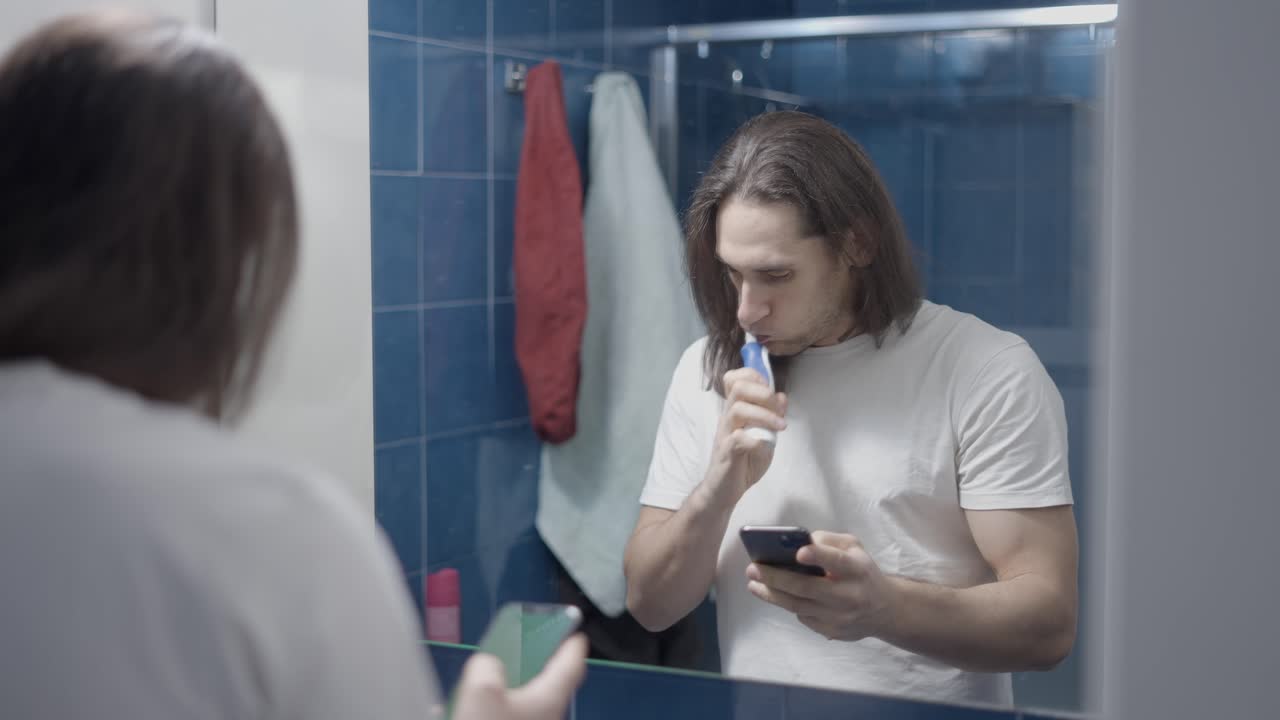 Uomo che si lava i denti in bagno
