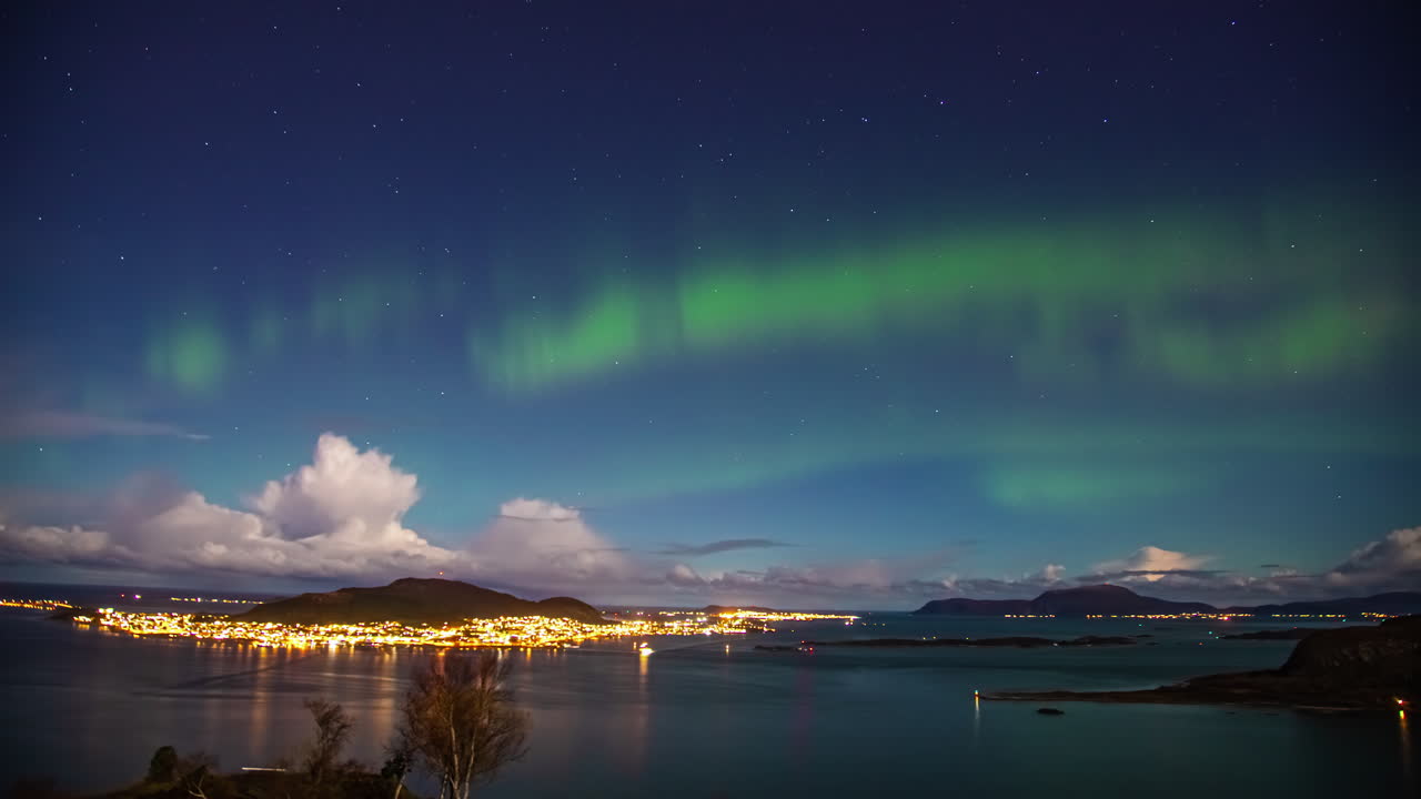 lapso de tiempo de las luces del norte que brillan sobre la ciudad iluminada por la noche de aalesund, noruega