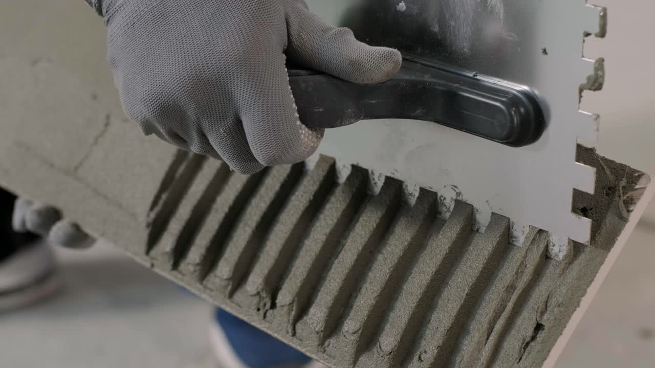 Construction, renovation, repair apartment. Installing ceramic floor tiles - measuring and cutting the pieces. Cuts tile. Tile cutting