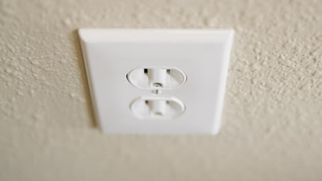 primer plano de la mano del hombre conectando el cable a la toma eléctrica y luego desenchufando en tiempo real