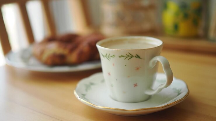 A Cup of Coffee and a Pastry on a Wooden Table