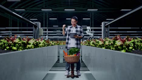 happy farmer using tablet in modern greenhouse