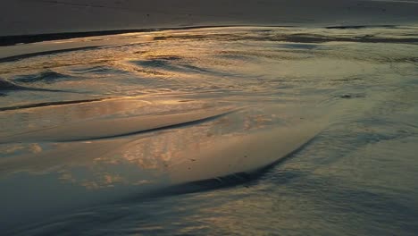 sunset on the beach: golden waves and reflections