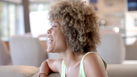relaxing on couch, woman laughing joyfully at home during leisure time, copy space