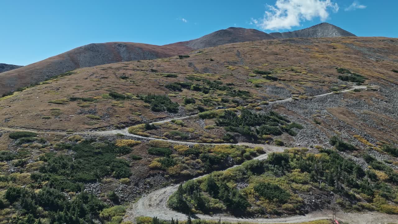 Stunning aerial orbit around car driving up switchbacks on Peak 10 trail Breckenridge Colorado