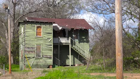 a decaying old tenement house sits in a field in jackson mississippi