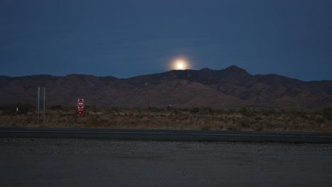 video del lapso de tiempo de la luna que se levanta sobre la cordillera con vehículos que pasan en nevada