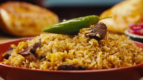 woman placing green pepper on a bowl of plov