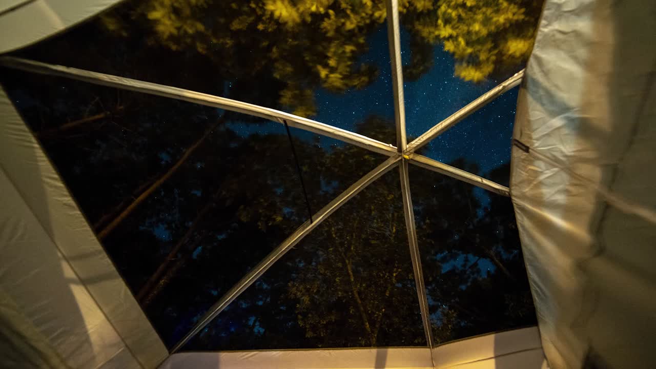 lapso de tiempo de las estrellas desde el interior de una tienda de campaña mientras acampa