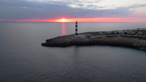 menorca from above, cap d’artrutx lighthouse at fire sky sunset coastline, ocean skyline and town