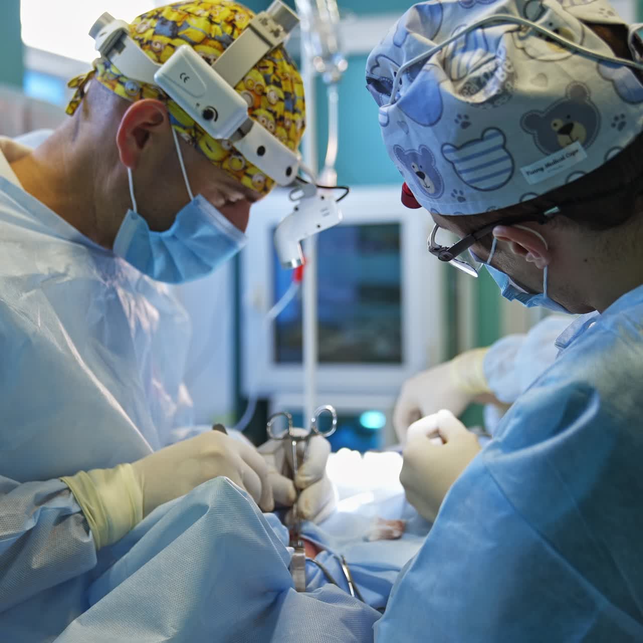 Surgeons collaborating and helping each other at operation. Assisting nurse passing the instruments to the doctors. Blurred backdrop