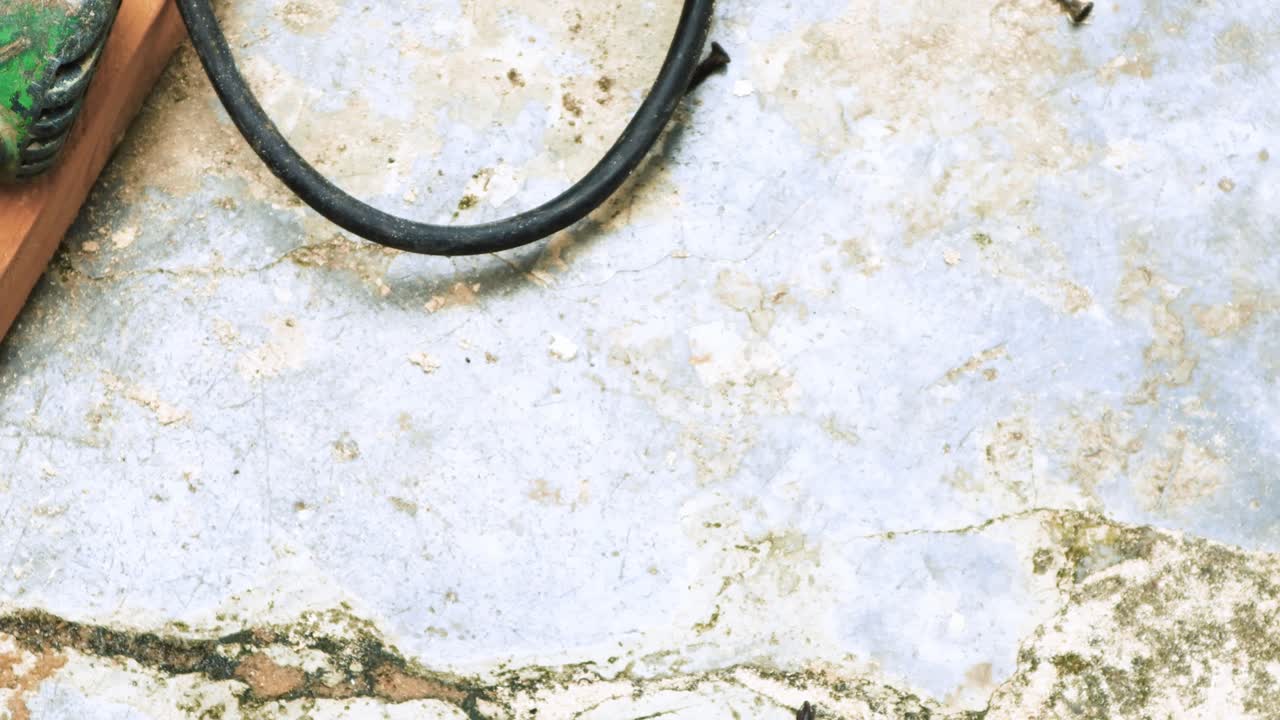 agarrar a mano una herramienta de destornillador del piso de concreto de un taller donde se realizan actividades de carpintería y construcción