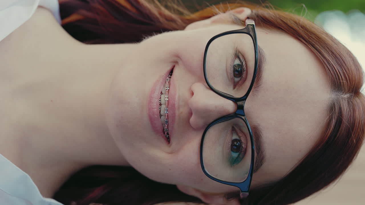Young Woman Smiling with Glasses and Braces