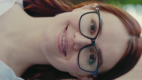 young woman smiling with glasses and braces