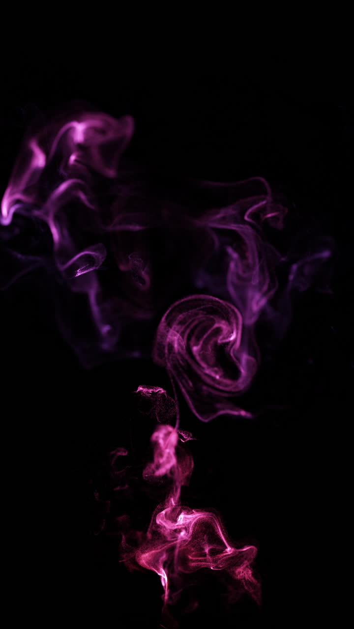 Vortici astratti di fumo di particelle rosa e viola su sfondo nero
