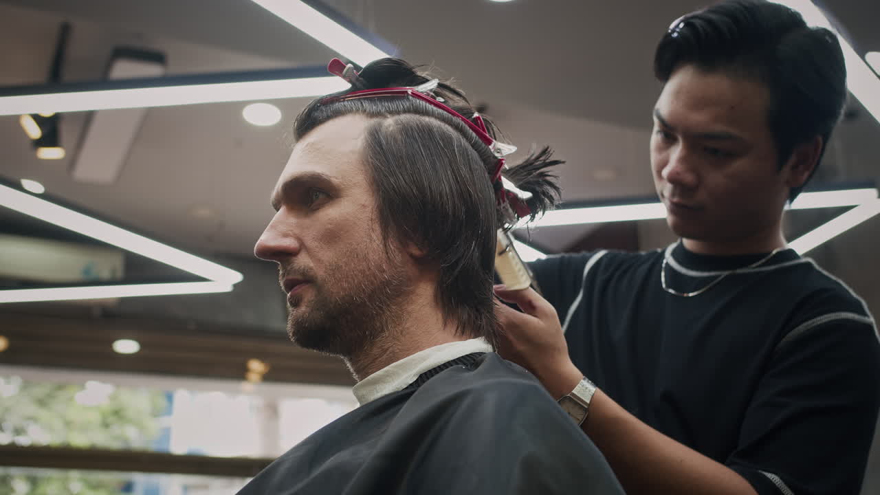 un hombre se corta el cabello en una barbería.