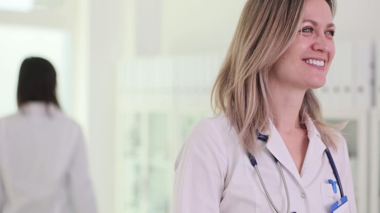 Two female doctors celebrate with a high-five in a clinic