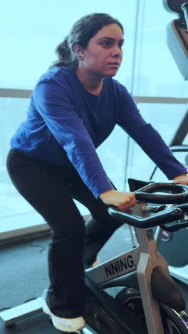 a woman is riding a stationary bike in a gym