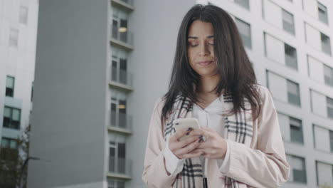 Businesswoman-texting-on-smartphone-at-street.-Focused-girl-using-mobile-phone