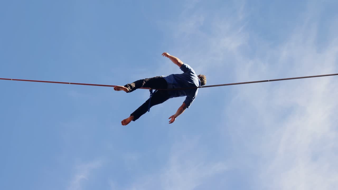 Man relaxing on tight rope 4k